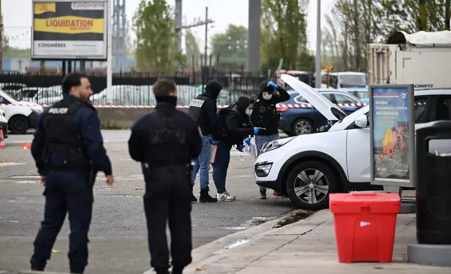 Police search a car at a gas station after a shooting in Trappes, outside Paris, Friday, Oct. 23, 2026. (AP Photo/Emma Da Silva)