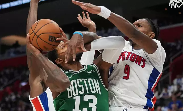 Boston Celtics forward Paul George (13) is fouled by Detroit Pistons forward Ausar Thompson (9) in the first half of an NBA basketball game in Detroit, Tuesday, Oct. 20, 2026. (AP Photo/Paul Sancya)