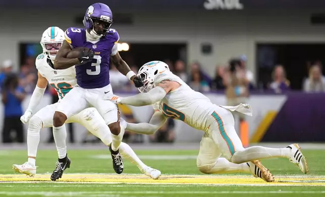 Minnesota Vikings wide receiver Jordan Addison (3) runs with the ball as Miami Dolphins linebacker Jacob Rodriguez, right, tries to tackle him during the second half of an NFL football game Sunday, Oct. 4, 2026, in Minneapolis. (AP Photo/Abbie Parr)