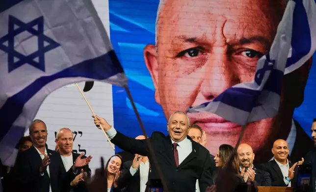 Gadi Eisenkot, leader of the Yashar ("Straight") party, waves an Israeli flag onstage following the release of the first exit poll results in Israel's general election in Tel Aviv, Israel, Wednesday, Oct. 28, 2026. (AP Photo/Ariel Schalit)