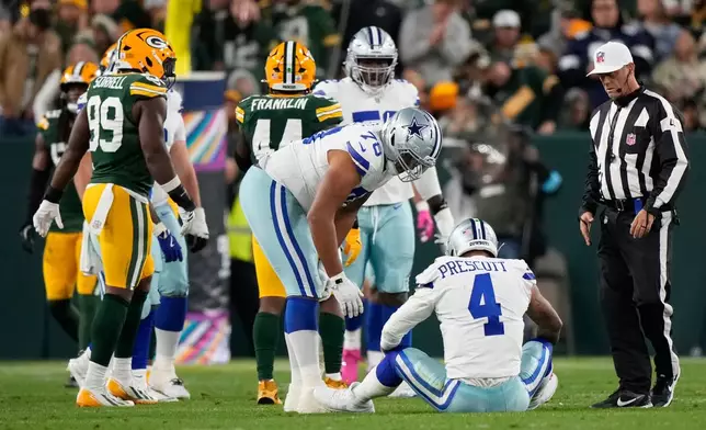 Dallas Cowboys' Dak Prescott reacts after being hit during the first half of an NFL football game against the Green Bay Packers in Green Bay, Wis., Sunday, Oct. 18, 2026. (AP Photo/Nam Huh)