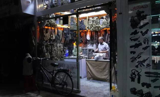 A shopkeeper works inside a store selling military equipment in Kabul's Mujahideen Market, formerly known as Bush Market before the Taliban returned to power, Sunday, Oct. 4, 2026.(AP Photo/Siddiqullah Alizai)