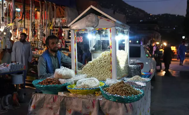 A street vendor sells popcorn in Kabul's Mujahideen Market, formerly known as Bush Market before the Taliban returned to power, Sunday, Oct. 4, 2026. (AP Photo/Siddiqullah Alizai)