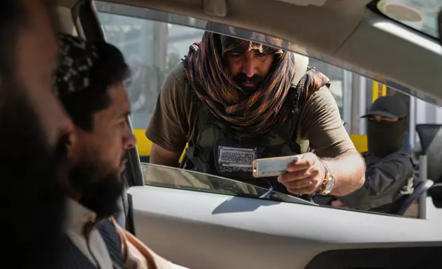 A Taliban security officer checks a motorist's documents on a road leading to the former U.S. Embassy, which has remained closed since the Taliban returned to power in 2021, in Kabul, Afghanistan, Monday, Oct. 5, 2026. (AP Photo/Siddiqullah Alizai)