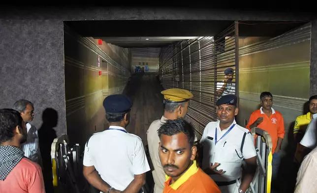 Police officers stand guard at the closed entrance to a worship venue for the Hindu festival of Durga Puja following a stampede, in Kolkata, India, Saturday, Oct. 17, 2026. (AP Photo)