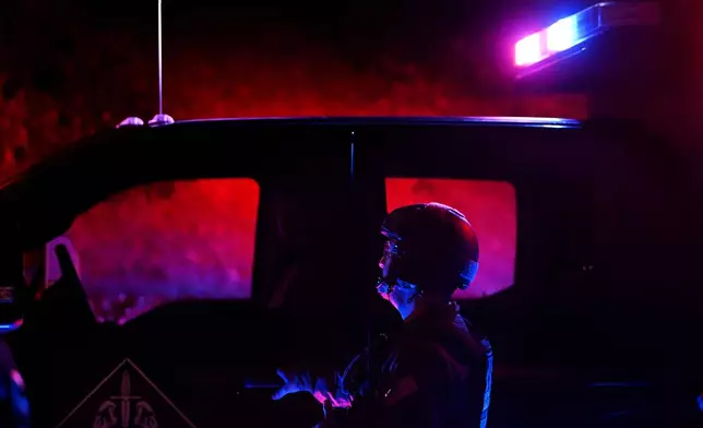 Federal agents arrive to a suspect's house during a raid related to health care fraud in the early morning on Thursday, Oct. 22, 2026, in Los Angeles. (AP Photo/Wally Skalij)