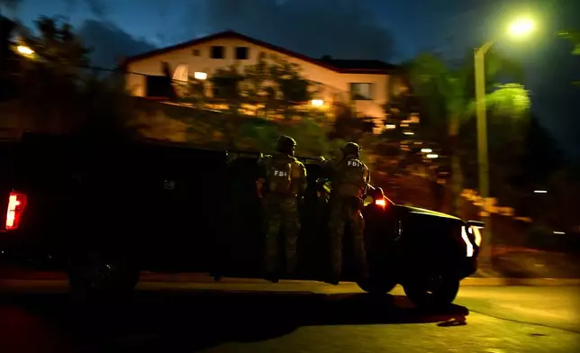 Federal agents arrive to a suspect's house during a raid related to health care fraud in the early morning on Thursday, Oct. 22, 2026, in Los Angeles. (AP Photo/Wally Skalij)