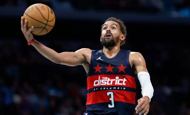 Washington Wizards guard Trae Young drives to the basket for a layup against the Charlotte Hornets during the second half of an NBA basketball game in Charlotte, N.C., Monday, Oct. 26, 2026. (AP Photo/Nell Redmond)