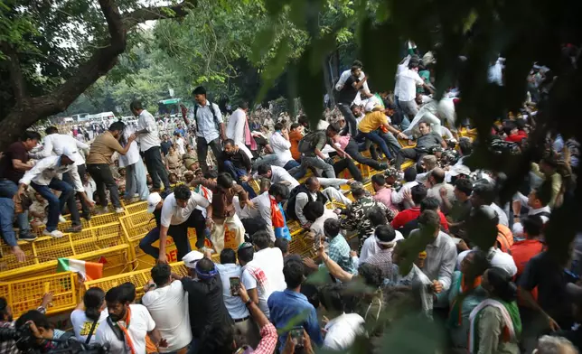 Activists and workers from various opposition parties try to breach police barricades during a protest march toward the Supreme Court demanding the resignation of Chief Election Commissioner Gyanesh Kumar in New Delhi, India, Monday, Oct. 12, 2026. (AP Photo/Prabhat Mehrotra)
