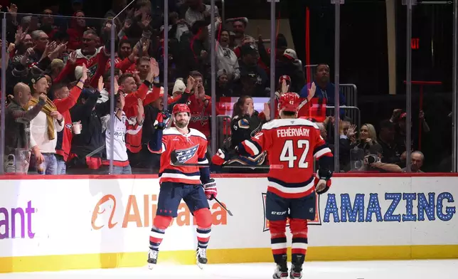 Washington Capitals center Boone Jenner, center left, celebrates after his goal with defenseman Martin Fehervary (42) during the second period of an NHL hockey game against the New York Rangers, Friday, Oct. 9, 2026, in Washington. (AP Photo/Nick Wass)