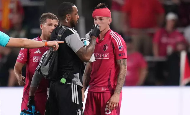 St. Louis City's Conrad Wallem (6) is tended to by a member of the medical staff after being injured during the first half of an MLS soccer match against the Vancouver Whitecaps Wednesday, Oct. 14, 2026, in St. Louis. (AP Photo/Jeff Roberson)