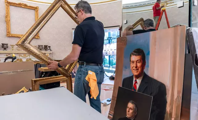 A replica of President Donald Trump's Oval Office is updated to the current decor by workers at "The People's House: A White House Experience," in Washington, Friday, Oct. 2, 2026. (AP Photo/J. Scott Applewhite)