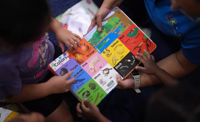 Children look through a book of first words at a Head Start preschool in Immokalee, Fla., Thursday, Sept. 10, 2026. (AP Photo/Rebecca Blackwell)