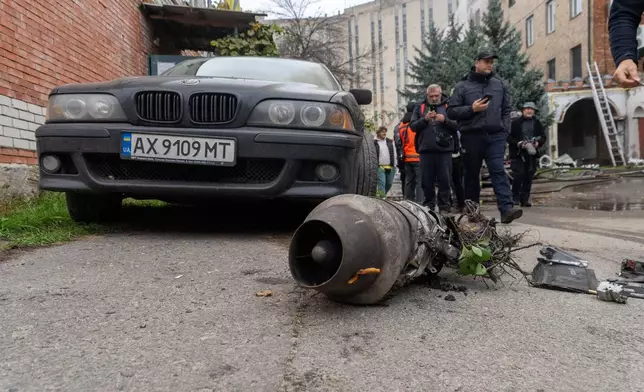 People pass by a fragment of a Russian jet drone after a Russian air attack in Kharkiv, Ukraine, Friday, Oct. 23, 2026. (AP Photo/Andrii Marienko)