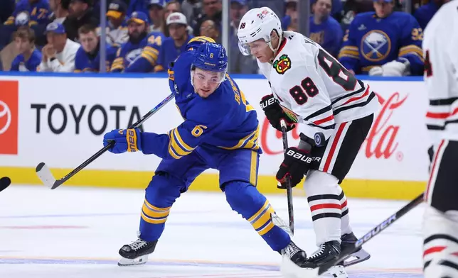 Buffalo Sabres left wing Zach Benson (6) and Chicago Blackhawks right wing Patrick Kane (88) battle for position during the first period of an NHL hockey game Saturday, Oct. 3, 2026, in Buffalo, N.Y. (AP Photo/Jeffrey T. Barnes)