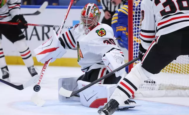 Chicago Blackhawks goaltender Spencer Knight (30) makes a save during the first period of an NHL hockey game agaunst the Buffalo Sabres, Saturday, Oct. 3, 2026, in Buffalo, N.Y. (AP Photo/Jeffrey T. Barnes)