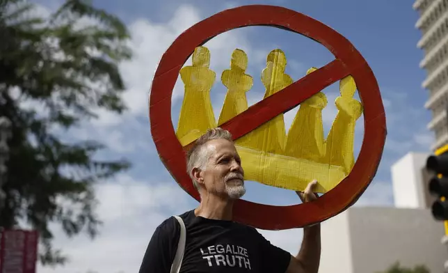 A demonstrator holds a "No Kings" sign during a protest in Los Angeles on Saturday, Oct. 17, 2026. (AP Photo/Caroline Brehman)