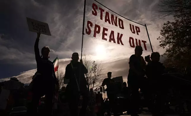 Marchers are silhouetted against the afternoon sky during a "No Kings" rally encouraging early voting in Seattle, Saturday, Oct. 17, 2026. (AP Photo/Lindsey Wasson)