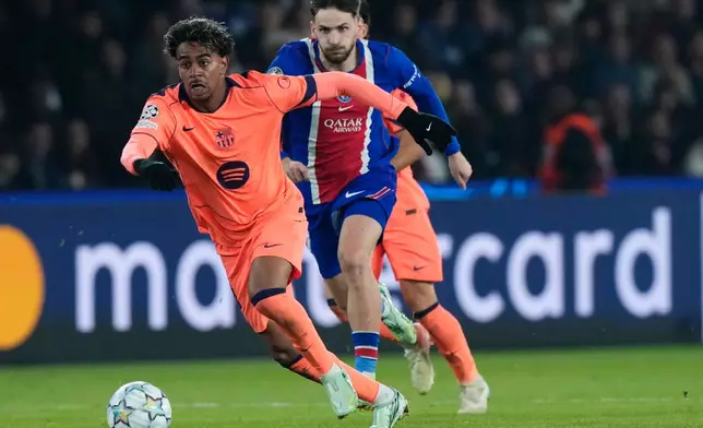 Barcelona's Lamine Yamal, left, is challenged by PSG's Khvicha Kvaratskhelia during the Champions League opening phase soccer match between Paris Saint-Germain and FC Barcelona in Paris, Tuesday, Oct. 20, 2026. (AP Photo/Teresa Suarez)