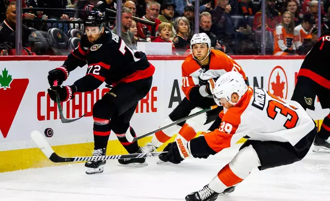 Ottawa Senators' Thomas Chabot (72) clears the puck while under pressure from Philadelphia Flyers' Tyson Foerster (71) and Matvei Michkov (39) during the first period of an NHL hockey game in Ottawa, Ontario, Thursday, Oct. 8, 2026. (Keito Newman/The Canadian Press via AP)