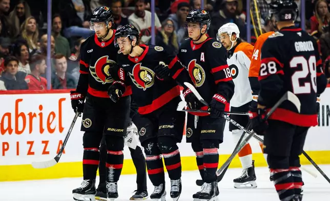 Ottawa Senators' William Eklund, second fom left, is helped off the ice after sustaining an injury during the first period of an NHL hockey game against the Philadelphia Flyers in Ottawa, Ontario, Thursday, Oct. 8, 2026. (Keito Newman/The Canadian Press via AP)