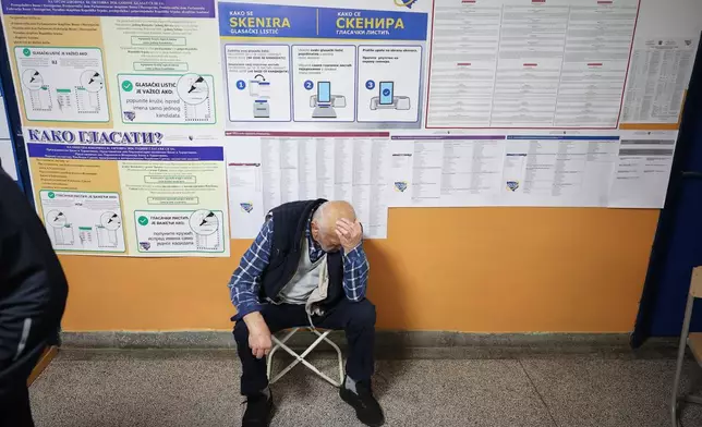 An elderly man waits, backdropped by posters with voting instructions, to cast his ballot during the general election in Sarajevo, Bosnia, Sunday, Oct. 4, 2026. (AP Photo/Armin Durgut)