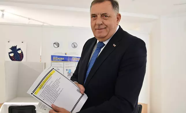 Milorad Dodik, former president of the Serb-majority Republika Srpska shows a ballot paper at a polling station in Laktasi, northwest of Sarajevo, Bosnia, Sunday, Oct. 4, 2026. (AP Photo/Radivoje Pavicic)