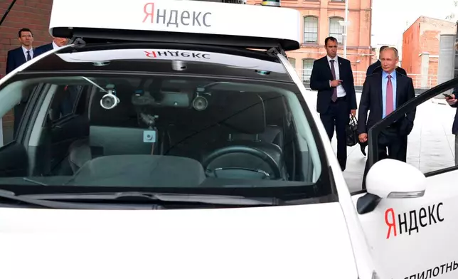 FILE - Russian President Vladimir Putin, right, examines the current prototype of an unmanned vehicle during his visits Russia's largest internet search engine Yandex headquarters in Moscow, Russia, on Sept. 21, 2017. (Alexei Druzhinin, Sputnik, Kremlin Pool Photo via AP, File)