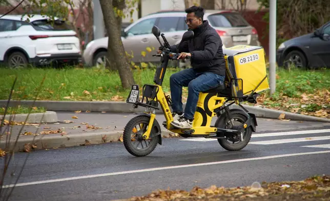 A Yandex food delivery courier rides his scooter in Moscow, Russia, Sunday, Oct. 11, 2026. (AP Photo/Alexander Zemlianichenko)