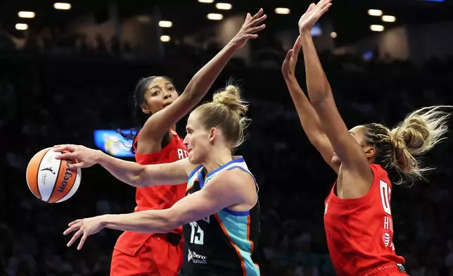 New York Liberty forward Leonie Fiebich, center, passes the ball against Atlanta Dream forwards Angel Reese, left, and Naz Hillmon, right, during the first half of Game 3 of the WNBA basketball semifinals, Friday, Oct. 9, 2026, in New York. (AP Photo/Heather Khalifa)