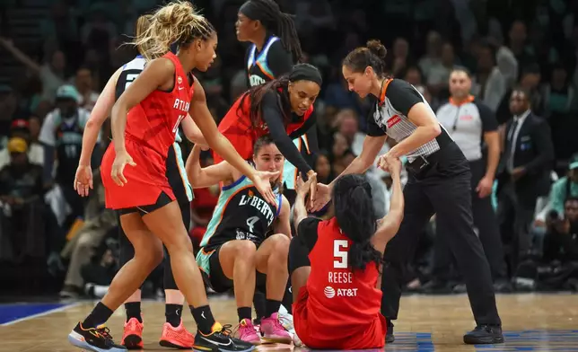 New York Liberty guard Marine Fauthoux (4) and Atlanta Dream forward Angel Reese (5) are helped up after a collision during the second half of Game 3 of the WNBA basketball semifinals, Friday, Oct. 9, 2026, in New York. (AP Photo/Heather Khalifa)