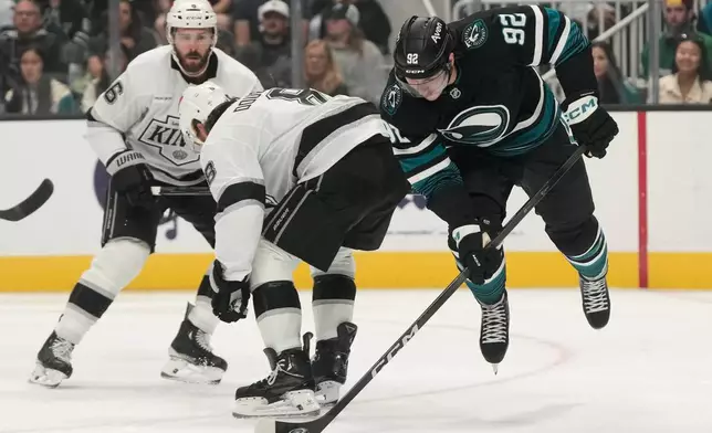 San Jose Sharks left wing Igor Chernyshov (92) reaches for the puck against Los Angeles Kings defenseman Drew Doughty during the first period of an NHL hockey game, Saturday, Oct. 3, 2026, San Jose, Calif. (AP Photo/Jeff Chiu)