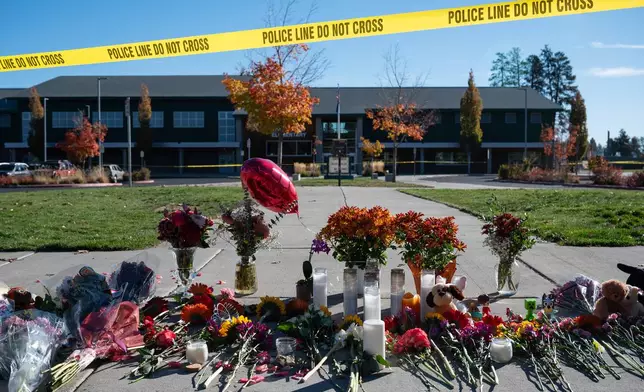 Flowers and candles are seen at a makeshift memorial outside Silver Rail Elementary in Bend, Ore., Friday, Oct. 16, 2026, a day after a deadly shooting. (AP Photo/Joe Kline)