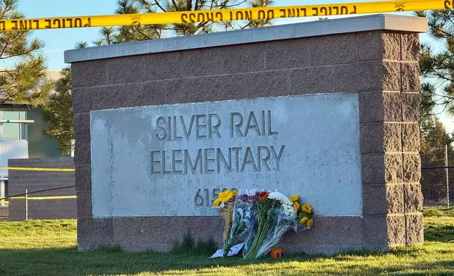 Flowers are placed beside a sign at Silver Rail Elementary School in Bend, Ore., on Friday, Oct. 16, 2026, a day after a deadly shooting. (AP Photo/Haven Daley)