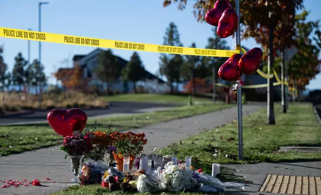 Flowers and candles are seen at a makeshift memorial outside Silver Rail Elementary in Bend, Ore., Friday, Oct. 16, 2026, a day after a deadly shooting. (AP Photo/Joe Kline)