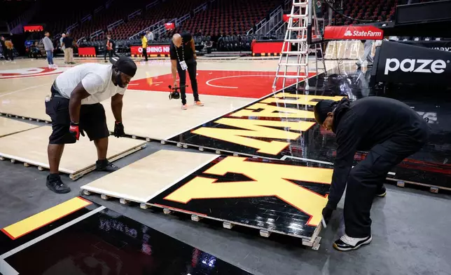 Workers quickly assemble the Atlanta Hawks court after Game 4 between WNBA Finals before the Hawks host the Houston Rocket in the home-opener NBA basketball game, Saturday, Oct. 24, 2026, in Atlanta. (AP Photo/Erik S. Lesser)