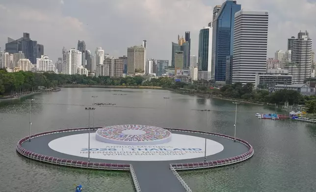 A person rows a boa beside a logo displayed at the Queen Sirikit National Convention Center ahead of the annual meetings of the International Monetary Fund (IMF) and the World Bank group in Bangkok, Thailand, Friday, Oct. 9, 2026. (AP Photo/Sakchai Lalit) (edited)
