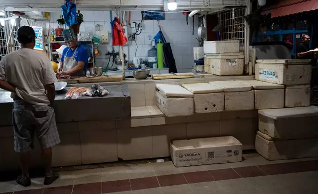 Boxes of Chilean salmon sit at a fish market in Santiago, Chile, Wednesday, Dec. 17, 2025. (AP Photo/Adriana Thomasa)