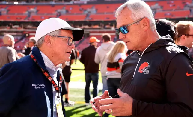 FILE - Ohio Gov. Mike DeWine talks with former Ohio State coach Jim Tressel while standing on the sideline prior to the start of an NFL football game between the Cincinnati Bengals and the Cleveland Browns, Oct. 20, 2024, in Cleveland. (AP Photo/Kirk Irwin, File)