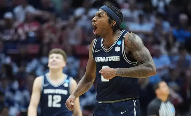 FILE - Utah State guard MJ Collins, who has since transferred to Cincinnati, celebrates during the second half in the first round of the NCAA college basketball tournament against Villanova, Friday, March 20, 2026, in San Diego. (AP Photo/Marcio Jose Sanchez, File)