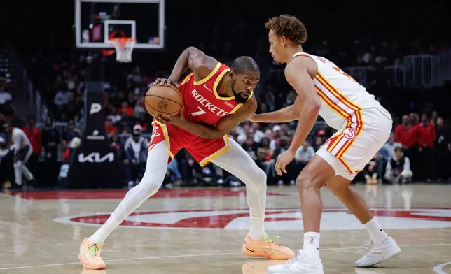 Houston Rockets forward Kevin Durant (7) drives against Atlanta Hawks guard Dyson Daniels, right, during the first half of an NBA basketball game, Saturday, Oct. 24, 2026, in Atlanta. (AP Photo/Erik S. Lesser)