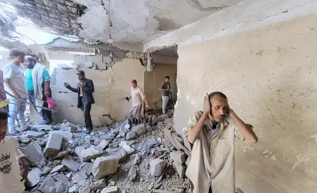 Residents walk on debris of their homes at Seina district in Taiz, Yemen, after a missile strike, Tuesday, Oct. 20, 2026. (AP Photo/Marzouq Al Jabri)
