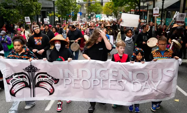 FILE - Young people hold a banner as they lead a celebratory march for Indigenous Peoples Day, Oct. 9, 2023, in Seattle. (AP Photo/Lindsey Wasson, file)