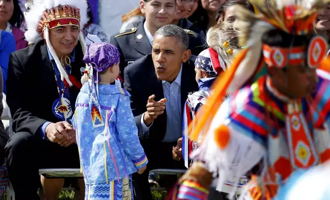FILE - President Barack Obama talks to two young boys during a Native American dance on the Standing Rock Indian Reservation Friday, June 13, 2014, photo in Cannon Ball, N.D. (AP Photo/Charles Rex Arbogast,File)