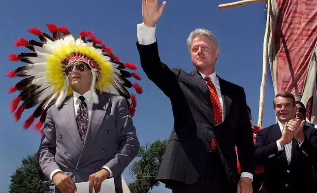 FILE - President Clinton waves as he takes the stage with Harold Salway, tribal president of the Oglala Sioux nation Wednesday, July 7, 1999 on the Pine Ridge Indian Reservation in S.D. (AP Photo/J. Scott Applewhite,File)