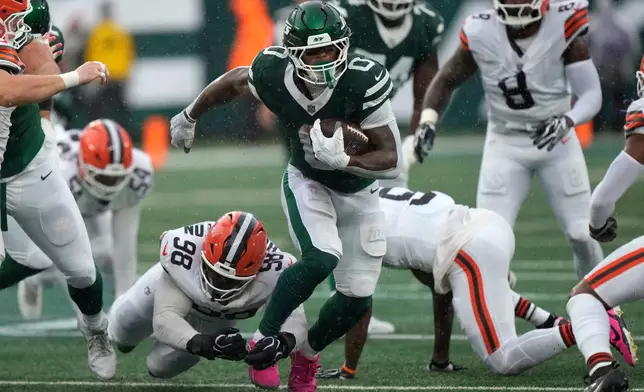 New York Jets running back Braelon Allen (0) runs from Cleveland Browns defensive end Adin Huntington (98) during the first half of an NFL football game, Sunday, Oct. 11, 2026, in East Rutherford, N.J. (AP Photo/Seth Wenig)
