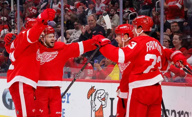 Detroit Red Wings left wing Viktor Arvidsson, second from right, celebrates with, from left, center Dylan Larkin, right wing Alex DeBrincat and left wing Lucas Raymond (23) during the second period of an NHL hockey game Tuesday, Oct. 6, 2026, in Detroit. (AP Photo/Duane Burleson)