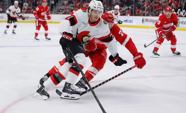 Ottawa Senators center Ridly Greig (71) is closely guarded by Detroit Red Wings defenseman Justin Faulk (72) during the first period of an NHL hockey game Tuesday, Oct. 6, 2026, in Detroit. (AP Photo/Duane Burleson)
