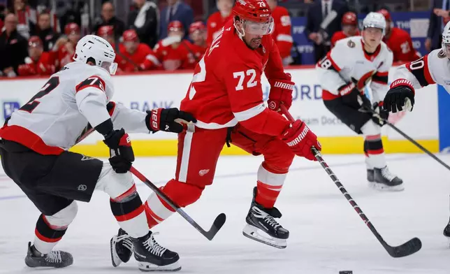 Detroit Red Wings center Dylan Larkin (71) drives the puck past Ottawa Senators defenseman Thomas Chabot, left, to score during the second period of an NHL hockey game Tuesday, Oct. 6, 2026, in Detroit. (AP Photo/Duane Burleson)