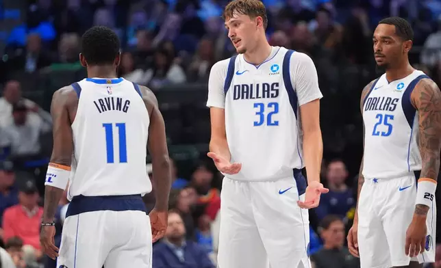 Dallas Mavericks forward Cooper Flagg (32) talks with guard Kyrie Irving (11) as forward P.J. Washington (25) looks on during the second half of a preseason NBA basketball game against the Atlanta Hawks in Dallas, Friday, Oct. 16, 2026. (AP Photo/LM Otero)